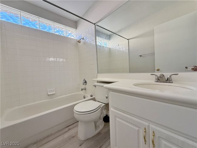 Bathroom with vanity, toilet, bathing tub / shower combination, and wood finished floors | Image 40