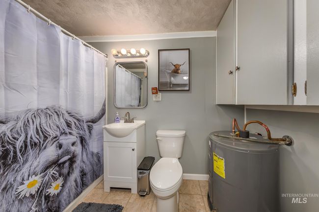 Bathroom with electric water heater, vanity, and a textured ceiling | Image 14