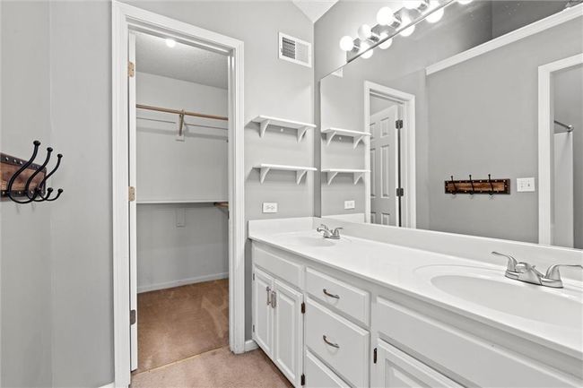 Bathroom with double vanity, a textured ceiling, and a walk in closet | Image 20