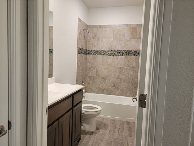 Bathroom with wood finished floors, bathtub / shower combination, toilet, and vanity | Image 23