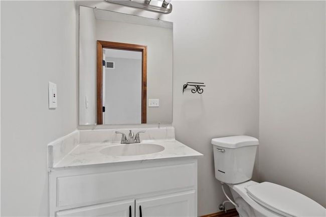 Bathroom with toilet, vanity, and visible vents | Image 15
