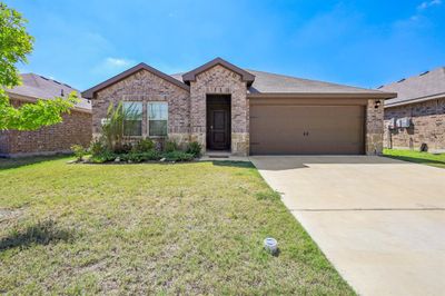 View of front facade featuring a front yard and a garage | Image 1