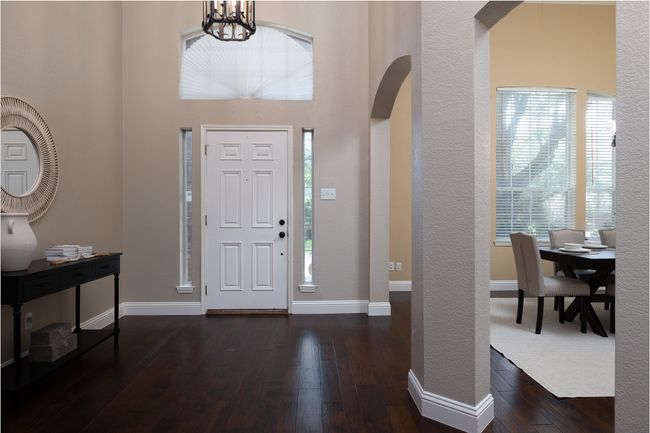 Entryway with dark wood-style floors, arched walkways, a chandelier, and a high ceiling | Image 4