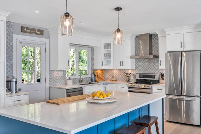 Kitchen with a sink, stainless steel appliances, decorative backsplash, wall chimney exhaust hood, and white cabinetry | Image 6