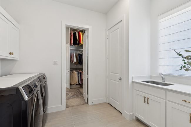 Washroom featuring cabinet space, independent washer and dryer, and light tile patterned floors | Image 20
