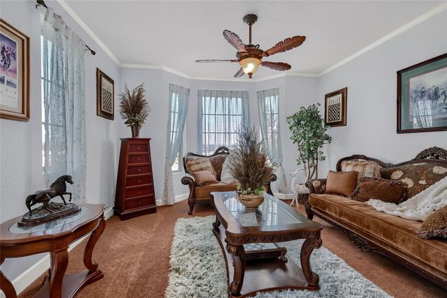 Living area featuring carpet floors, ceiling fan, and ornamental molding | Image 25