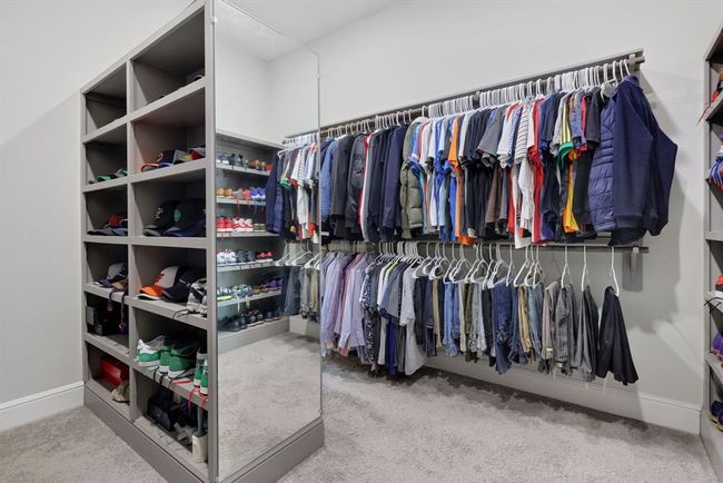 Spacious walk-in closet featuring ample shelving for shoes and accessories, plus extensive hanging space for clothes. | Image 31