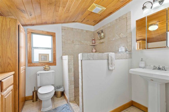 Bathroom with vaulted ceiling, wood ceiling, and tile patterned flooring | Image 20