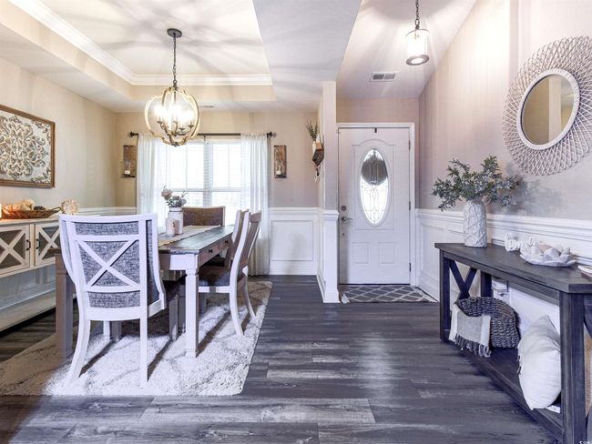 Dining area featuring dark hardwood / wood-style flooring, a raised ceiling, and a chandelier | Image 9