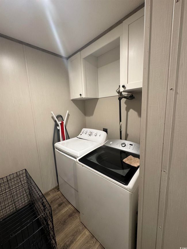 Laundry room featuring cabinet space, independent washer and dryer, and wood finished floors | Image 9