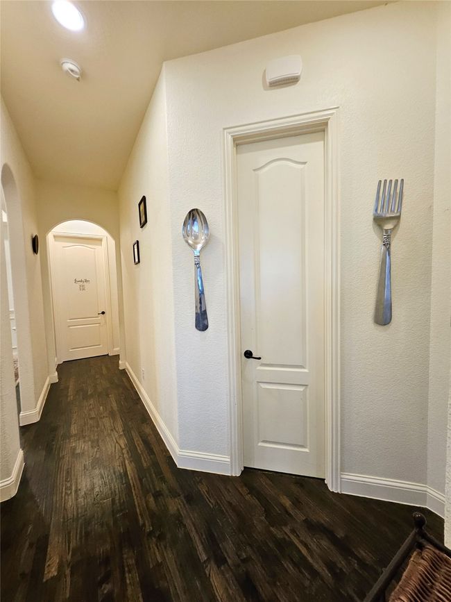 Hallway featuring dark wood-type flooring, arched walkways, and baseboards | Image 27