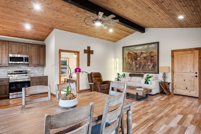 Dining space with wood ceiling, vaulted ceiling with beams, and light wood-style flooring | Image 16