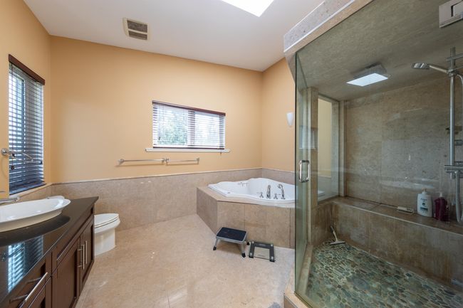 Bathroom featuring a stall shower, a garden tub, vanity, toilet, and tile patterned flooring | Image 27