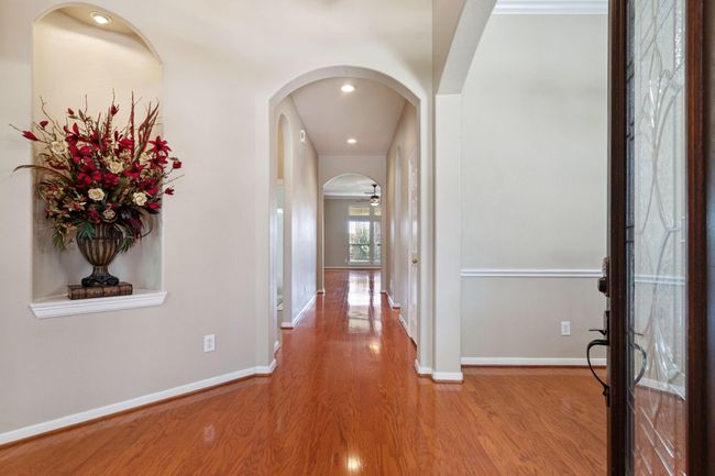 Wood floors in the well appointed foyer flow seamlessly to the back of the home | Image 8