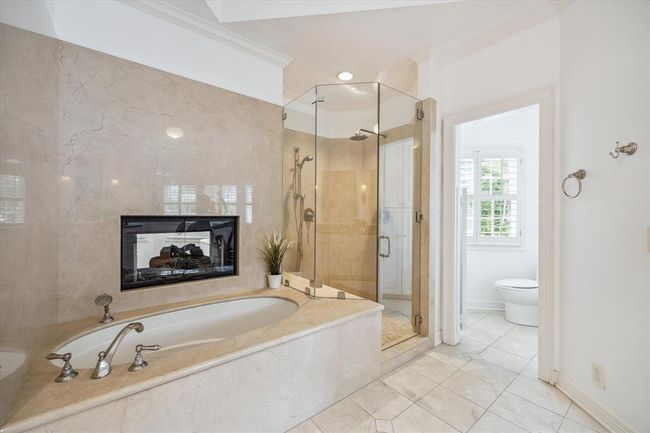 Primary bath soaking tub and walk-in shower. Enjoy a luxurious bath by the fire during the fall/winter! | Image 21
