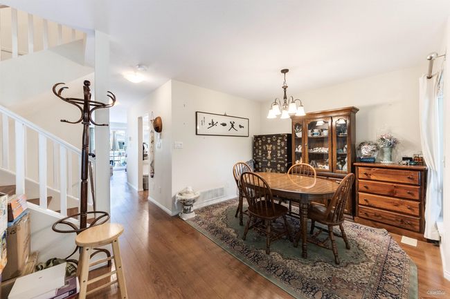 Dining room with stairs, wood finished floors, a chandelier, and baseboards | Image 9