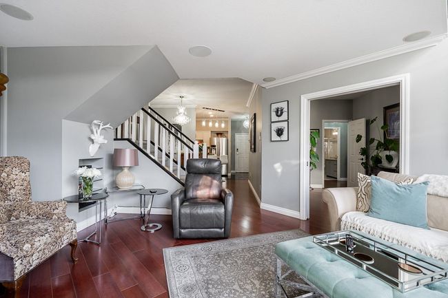 Living area featuring baseboards, wood finished floors, stairs, and ornamental molding | Image 13