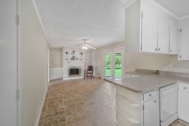 VIEW LOOKING FROM KITCHEN INTO DEN WITH FIREPLACE AND BUILT-INS. | Image 18