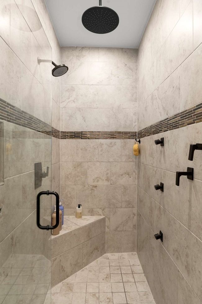 Primary bath has an additional rain shower head, body sprays and built in bench. | Image 22
