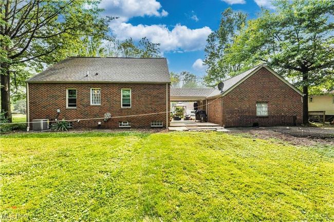 Back of house with a lawn, brick siding, central AC, and a patio area | Image 32