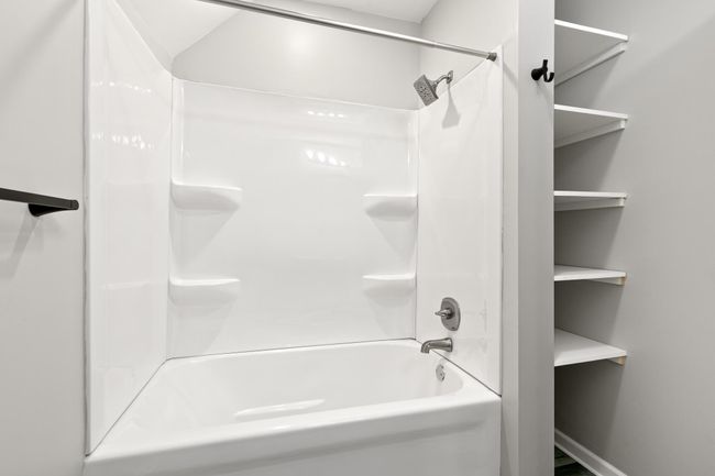 A large tub and shower with additional storage area on the side. | Image 18