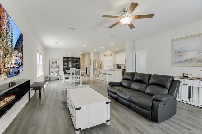 Living room with a ceiling fan, light wood-style flooring, and recessed lighting | Image 12