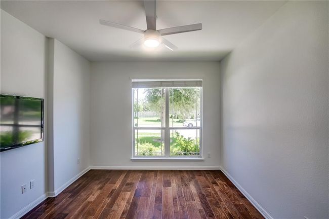 Spare room featuring dark wood finished floors and a ceiling fan | Image 6