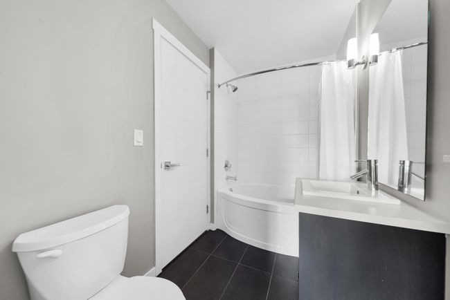 Bathroom with toilet, tile patterned floors, shower / bath combination with curtain, and vanity | Image 35