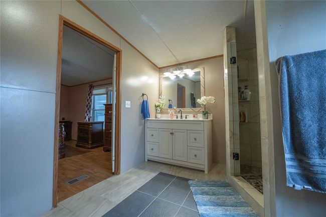 Bathroom featuring crown molding, hardwood / wood-style floors, vanity with extensive cabinet space, and a shower with shower door | Image 19