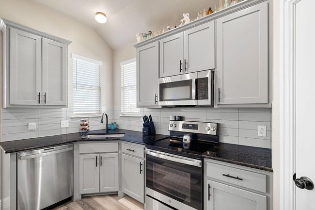 Kitchen with backsplash, appliances with stainless steel finishes, lofted ceiling, and a​​‌​​​​‌​​‌‌​‌‌​​​‌‌​​‌‌​‌​​​​​‌ sink | Image 12