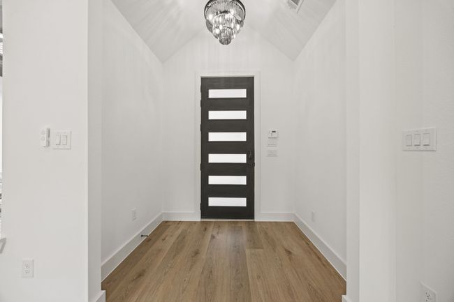 Entryway featuring a chandelier, vaulted ceiling, wood finished floors, and baseboards | Image 30