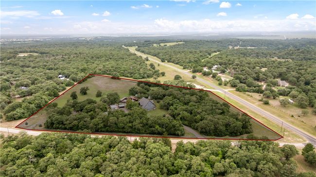 Aerial overview of property's location featuring a heavily wooded area and property parcel outlined | Image 30