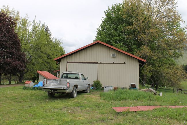 View of side of property with an outdoor structure, a yard, a pole building, and a garage | Image 6