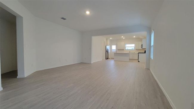Unfurnished living room featuring light wood-style floors, recessed lighting, and vaulted ceiling | Image 7