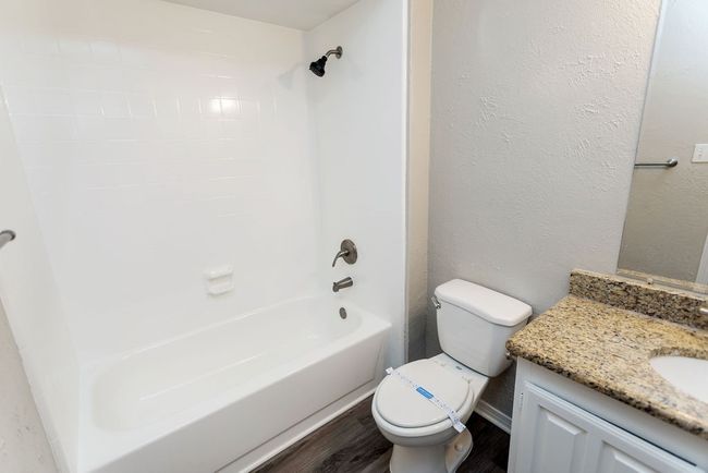 Bathroom featuring wood finished floors, vanity, and shower / washtub combination | Image 24