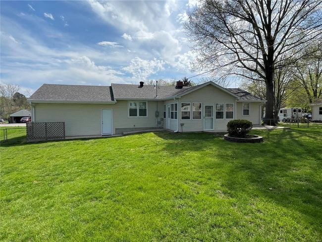 Rear view of house with a lawn, a shingled roof, and fence | Image 42