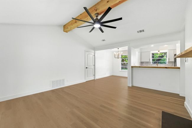 Unfurnished living room featuring a chandelier, ceiling fan, and wood finished floors | Image 4