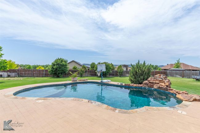 View of swimming pool with a patio area | Image 31