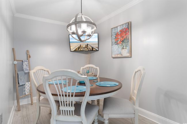 Dining space featuring a chandelier, baseboards, ornamental molding, and wood finished floors | Image 7