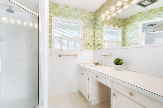 Primary Bathroom with vanity, a shower stall, wallpapered walls, and tile patterned floors | Image 20