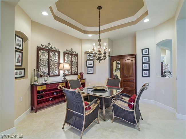 Tiled dining room featuring a notable chandelier, ornamental molding, and a tray ceiling | Image 11