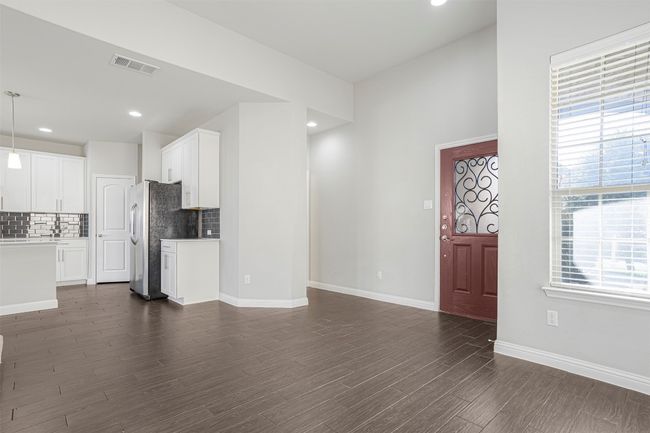 Unfurnished living room with dark wood-style floors and recessed lighting | Image 7