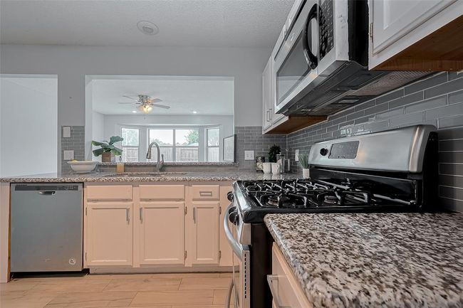 The kitchen is truly the heart of this home, thoughtfully designed with an open layout that seamlessly connects to both the sunroom and the spacious family room. | Image 9