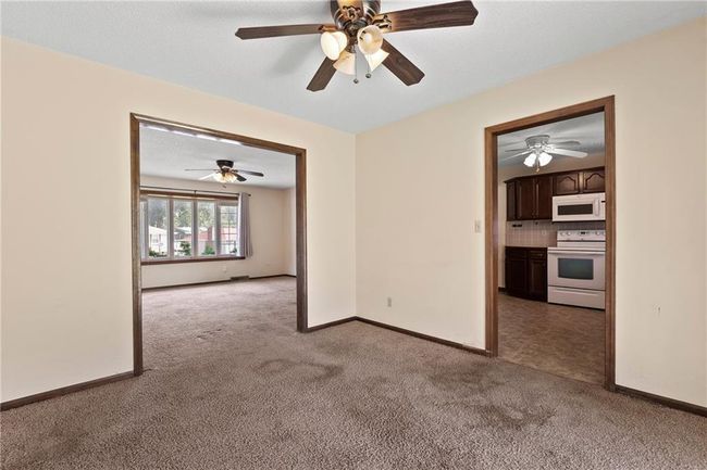 Empty room with carpet, ceiling fan, and baseboards | Image 9