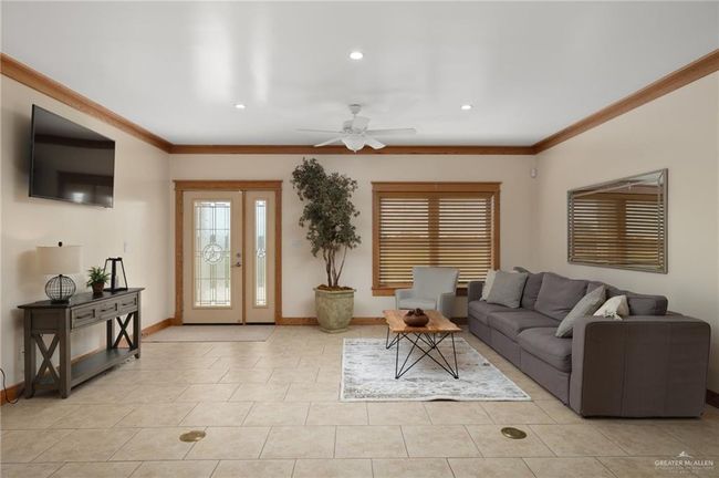 Tiled living room with ceiling fan and ornamental molding | Image 6
