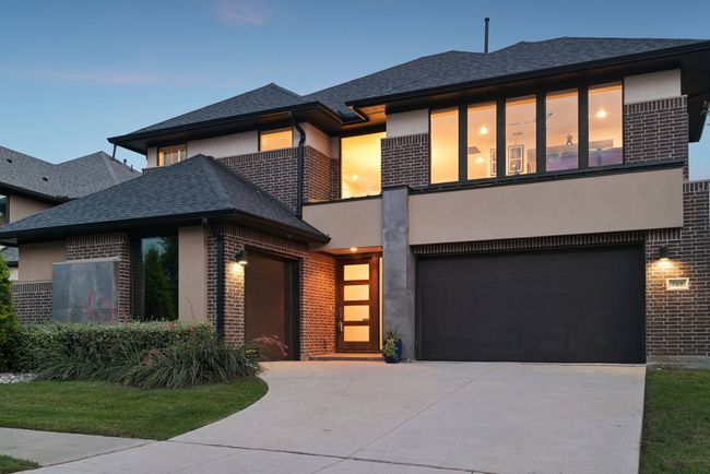 View of front of house with brick siding, stucco siding, and concrete driveway | Image 34