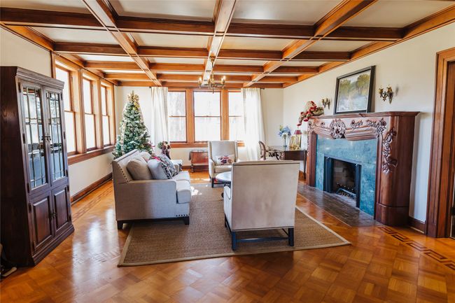 Living room with light parquet flooring, coffered ceiling, and a fireplace | Image 5