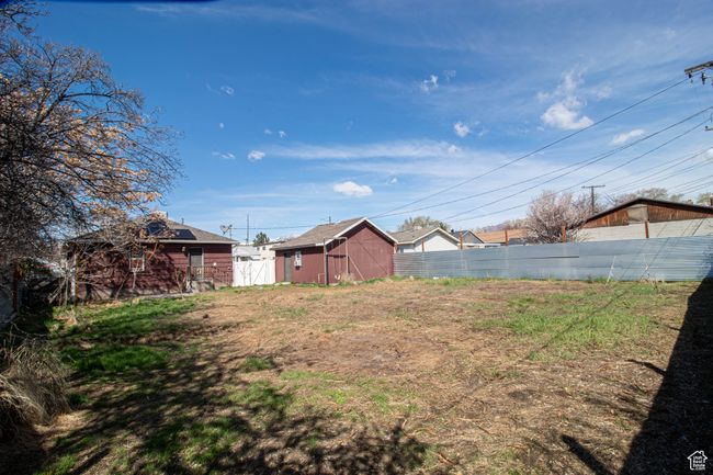 View of spacious back yard featuring fence and back of garage. | Image 17