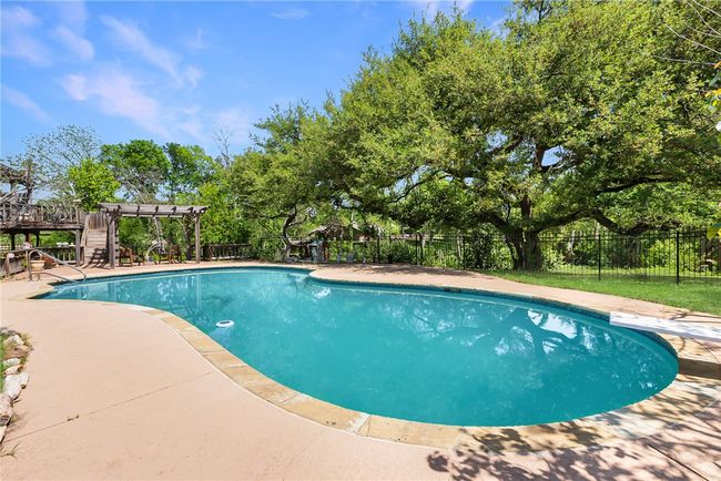 View of swimming pool featuring a pergola, a patio, a fenced backyard, and a fenced in pool | Image 36
