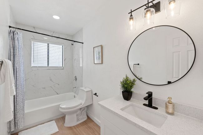Full bath featuring shower / bath combination with toilet, vanity, and finished floors | Image 20